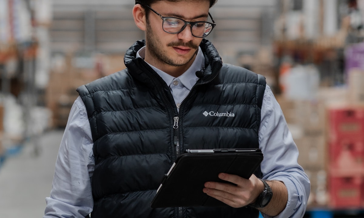 A warehouse employee reading output from a system on a tablet. Most companies meet the AI Act as a deployer, not as a builder.