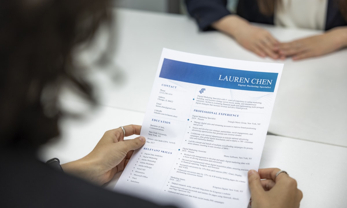 Een cv lezen aan tafel. AI bij werving en selectie is hoog risico volgens bijlage III, bij elke bedrijfsgrootte.