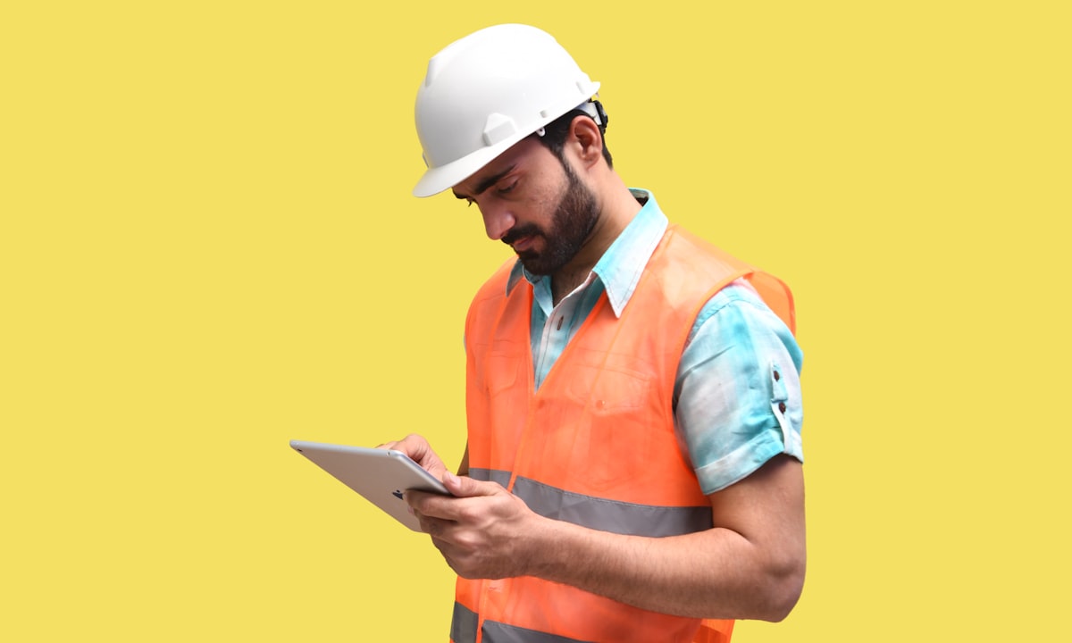 Checking a tablet on site. Old estimates against actual costs reveal where a company miscalculates.