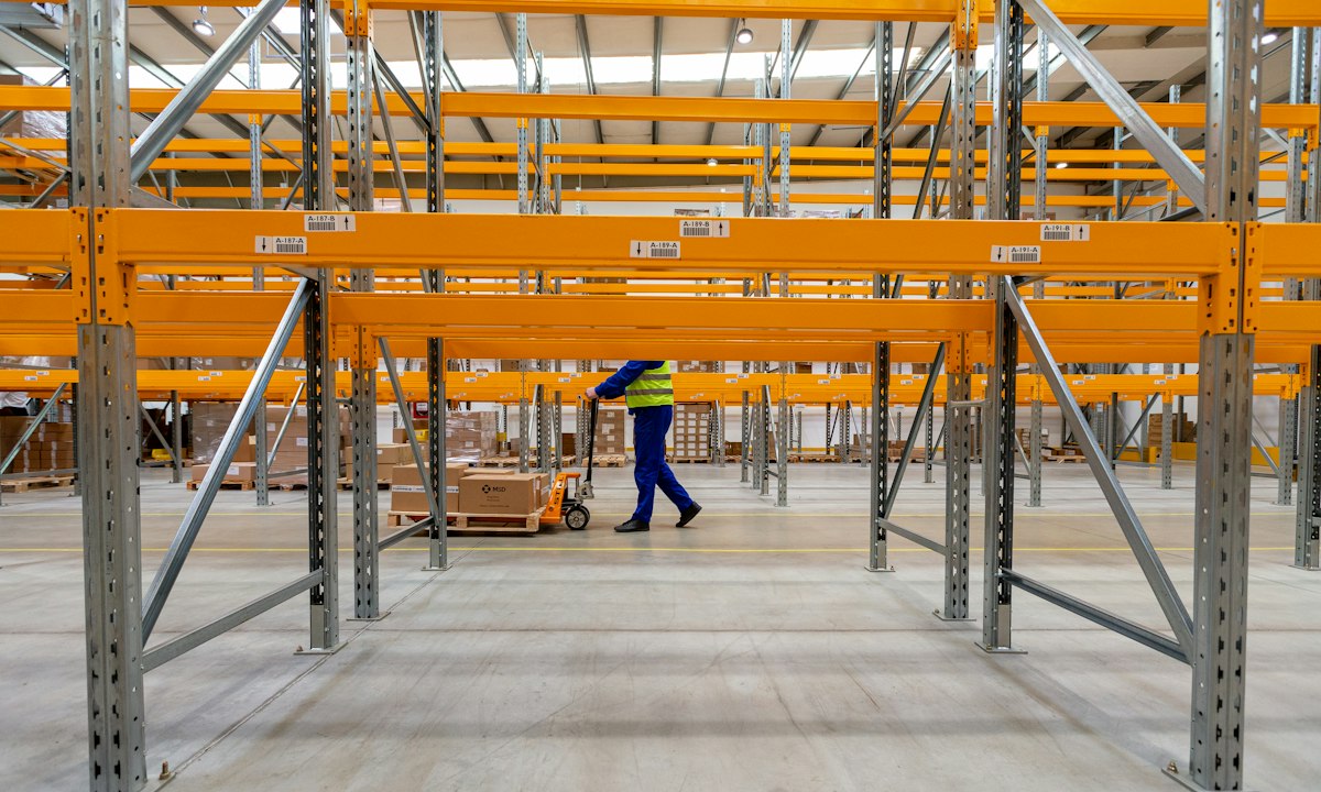 Empty rack positions in a warehouse. Ten percent less stock with the same delivery is working capital set free again.
