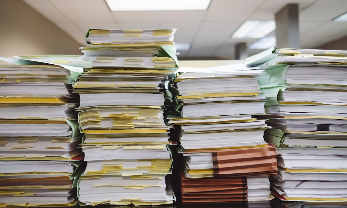 Stapels papieren dossiers. Dataklaarheid gaat niet over hoeveelheid, maar over de vraag of hetzelfde woord overal hetzelfde betekent.