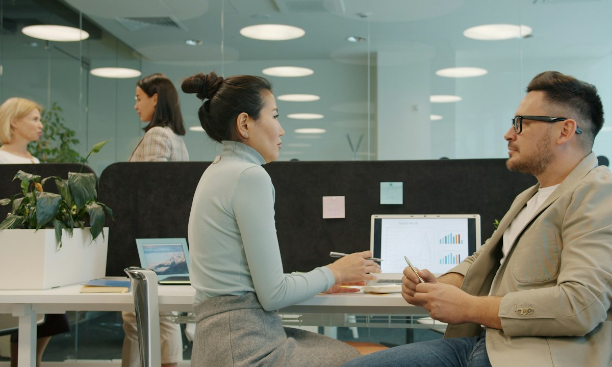 Twee collega's in gesprek aan hun bureau. De meeste zorgen over AI komen boven in een gesprek onder vier ogen, zelden in een volle vergadering.